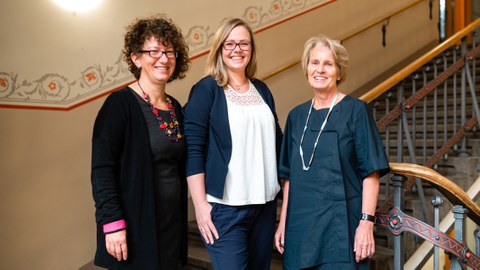 Das Foto zeigt das Team der Gleichstellungsarbeit der Fakultät Maschinenwesen der TU Dresden. Drei Frauen stehen nebeneinander in einem Treppenhaus.