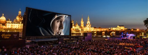Das Foto zeigt die Kulisse der Filmnächte am Elbufer in Dresden. Auf der großen Leinwand sieht man einen Ausschnitt des Filmes "Aufbruch zum Mond".