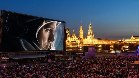 Das Foto zeigt die Kulisse der Filmnächte am Elbufer in Dresden. Auf der großen Leinwand sieht man einen Ausschnitt des Filmes "Aufbruch zum Mond".