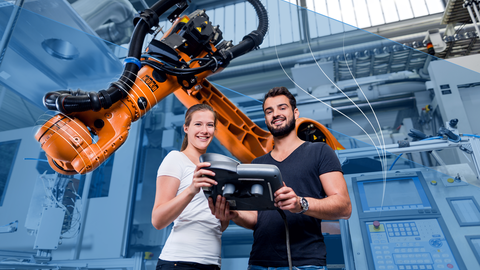 Auf dem Bild sind zwei Studierende an einem Roboter-Greifarm zu sehen