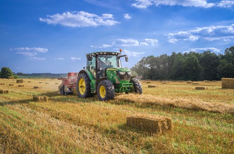 Auf dem Bild ist ein Traktor auf dem Feld zu sehen