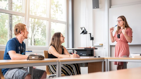 Auf dem Bild ist eine Lehrende und 2 Studierende zu sehen