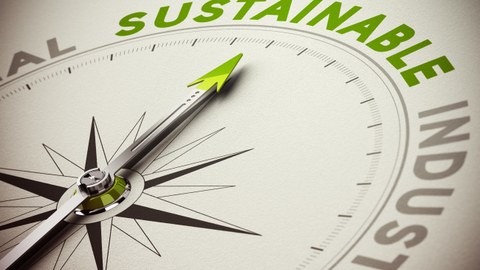Foto eines Kompasses mit einem grünen Pfeil, der auf das in grün geschriebene Wort "Sustainable" zeigt.