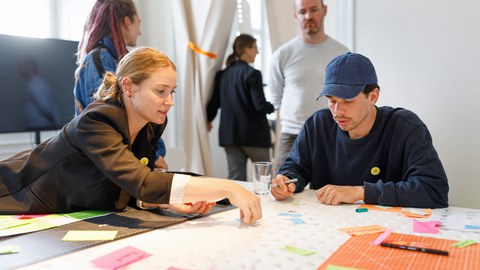 Auf dem Bild sind Mitarbeitende und Studierende des Technischen Designs der TUD zu sehen, die in einem Workshop zusammensitzen und brainstormen.