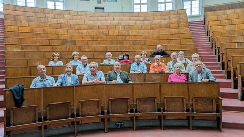 Ältere Alumni-Seminargruppe bestehend sitzt im Lichtenheldt-Hörsaal