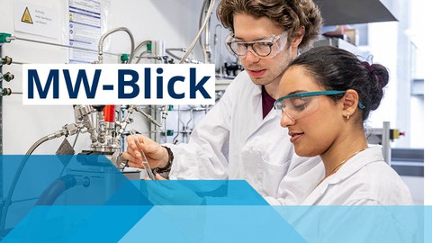 Zwei Studenten arbeiten in Labor mit Kitteln und Schutzbrillen und hantieren mit einer Pipette