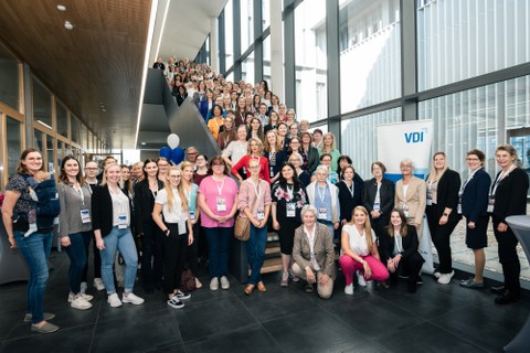 Gruppe von Frauen posiert auf Treppe.