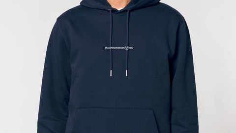 Auf dem Bild ist ein Mann mit einem dunkelblauen Hoodie zu sehen auf dem Maschinenwesen@TUD steht