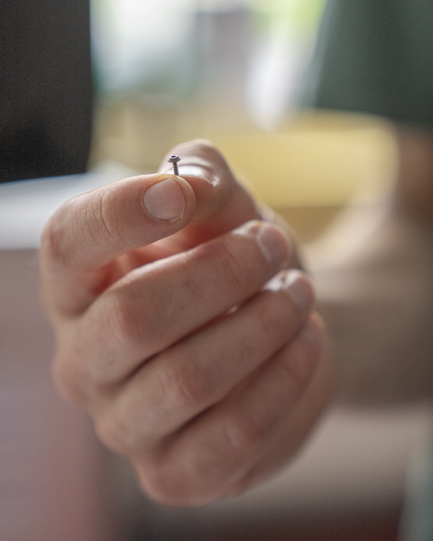 Eine Mikroschraube in der Hand