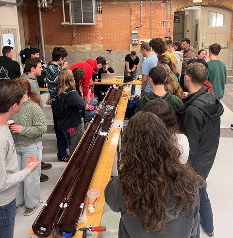 Teilnehmende des Knatterbootrennens stehen um die vier Meter lange Rennstrecke.