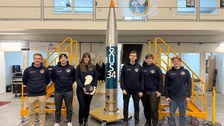 Das SHAMA-Team vor der vollständig integrierten Nutzlast der REXUS-34-Rakete. Die orangefarbenen Schutzhüllen umschließen bis zum Start die Experimentkomponenten. 