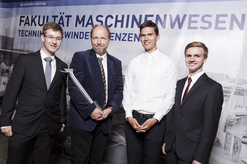 Professor Odenbach hält den Lehrpreis 2016 in der Hand. Neben ihm stehen drei Vertreter des Fachschaftsrates. 