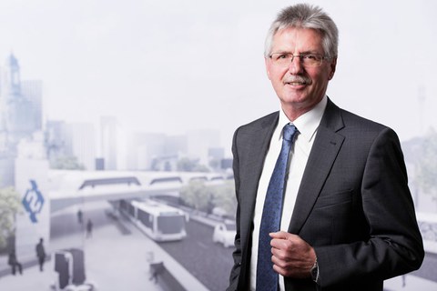 Foto von Professor Uwe Gampe vor dem Hintergrund einer virtuellen Stadtlandschaft