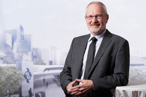 Foto von Professor Ullrich Hesse vor dem Hintergrund einer virtuellen Stadtlandschaft