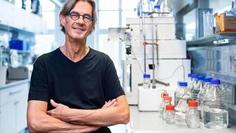 Foto von Professor Harald Rohm vor dem Hintergrund einer virtuellen Stadtlandschaft