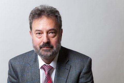 Das Portraitfoto zeigt Professor Jürgen Weber. er trägt ein graues Jacket und eine rot karierte Krawatte.
