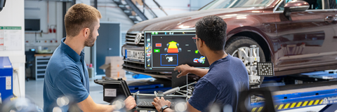 Auf dem Bild sind zwei Studierende zu sehen, die an einer Simulation sitzen. Im Hintergrund ist ein Auto zu sehen. Maschinenbau studieren Bachelor Diplom Master