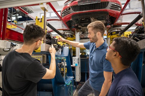 Auf dem Bild sind Studierende des Maschinenbaus an der TU Dresden zu sehen, die in einer Praxissituation in der Kraftfahrzeug- und Schienenfahrzeugtechnik fotografiert worden