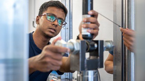 Auf dem Bild sind Studierende des Maschinenbaus an der TU Dresden zu sehen, die in einer Praxissituation in der Kraftfahrzeug- und Schienenfahrzeugtechnik fotografiert worden