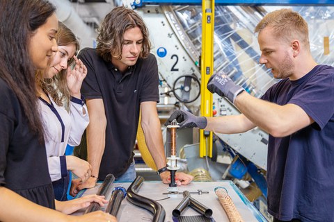 Maschinenbau studieren. Auf dem Bild sind Studierende des Maschinenbaus an der TU Dresden zu sehen, die in einer Praxissituation im Leichtbau fotografiert worden