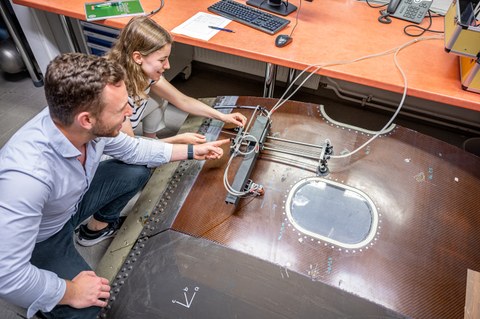 Auf dem Bild sind Studierende des Maschinenbaus an der TU Dresden zu sehen, die in einer Praxissituation in der Luft- und Raumfahrttechnik fotografiert worden