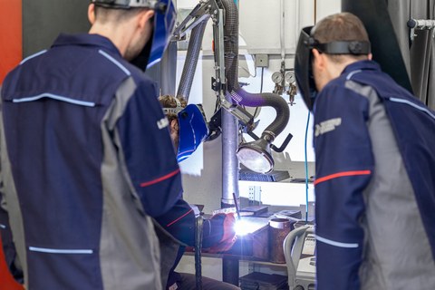 Auf dem Bild sind Studierende des Maschinenbaus an der TU Dresden zu sehen, die in einer Praxissituation in der Produktionstechnik fotografiert worden