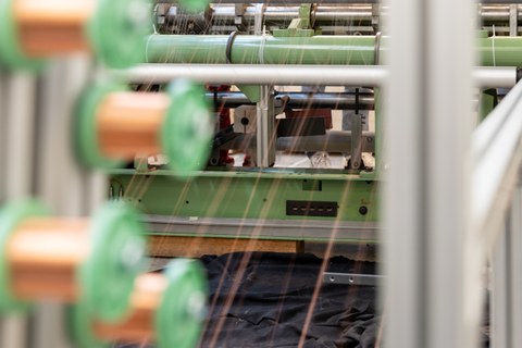 Auf dem Bild sind Studierende des Maschinenbaus an der TU Dresden zu sehen, die in einer Praxissituation in den Verarbeitungsmaschinen und Textilmaschinenbau fotografiert worden