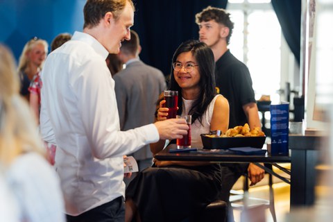 Junge Frau und junger Mann unterhalten sich bei einem Getränk