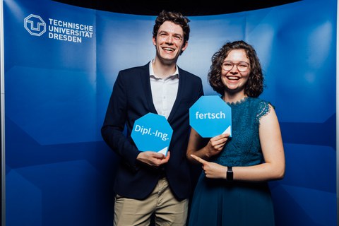 Junger Mann und junge Frau posieren vor Fotowand