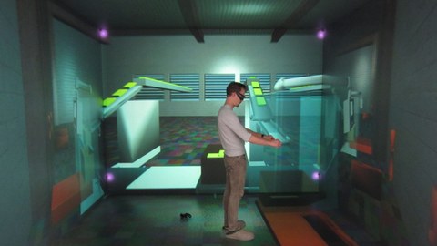 Auf dem Foto sieht man einen Mann mit VR-Brille, der in einer virtuellen Umgebung steht. 