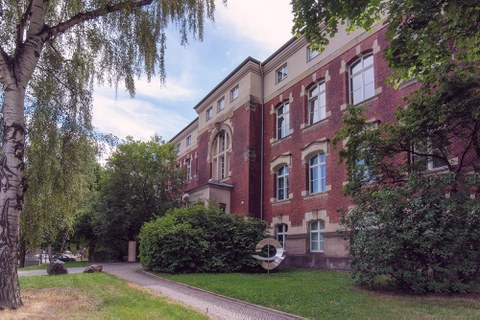 Außenansicht des Görges-Baus. Die Fassade besteht zu großen Teilen aus rotem Backstein und Sandsteinelementen. Vor dem Gebäude befindet sich eine metallische Skulptur.