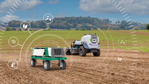 Zwei autonom fahrende Roboter auf einem Feld.