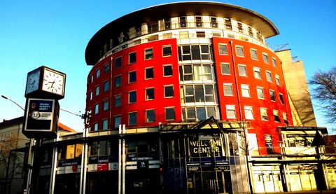 Das Foto zeigt ein Gebäude am Nürnberger Ei. Es ist rund gestaltet mit roter Fassade. 