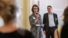 Professorin Roswitha Böhm, Prorektorin Universitätskultur, spricht in ein Mikrofon. Professor Ronald Tetzlaff ist im Hintergrund zu sehen.