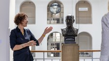 Foto von Frau Vincenz, Direktorin der Kustodie, mit der Büste von Hans Görges im Görges Bau