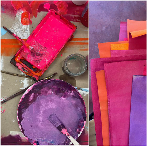 Auf der linken Seite sind zwei Farbpaletten zu sehen mit rosa und violetten Tönen. Auf der rechten Seite liegen Papiere in ähnlicher Farbkombination.