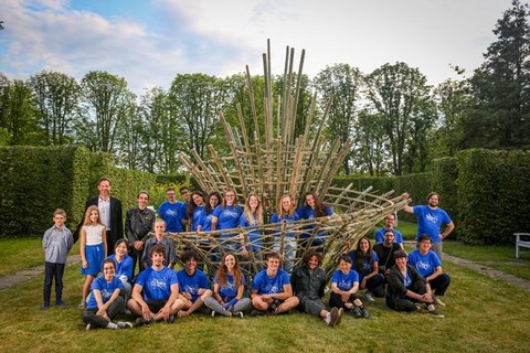 Gruppenfoto in einem Park mit einer Bambus-Kunstinstallation in der Mitte