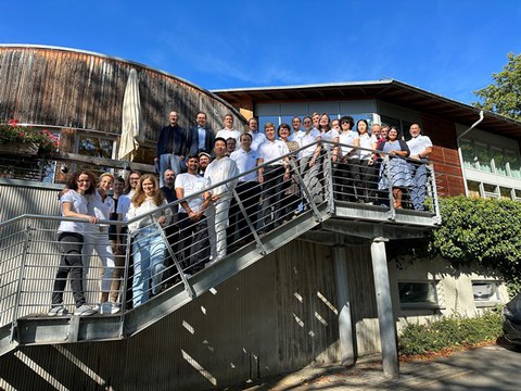 Gruppenfoto auf einer Treppe mit Geländer von unten