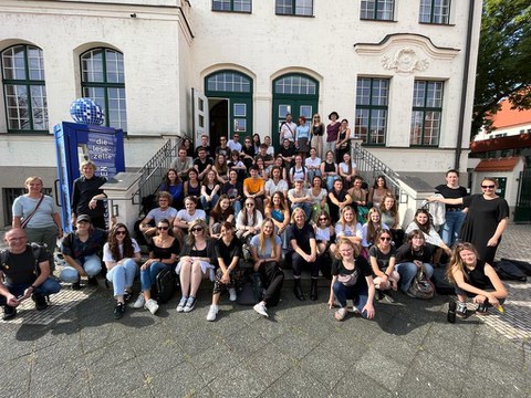 Gruppenfoto, auf und vor einer Treppe hockend