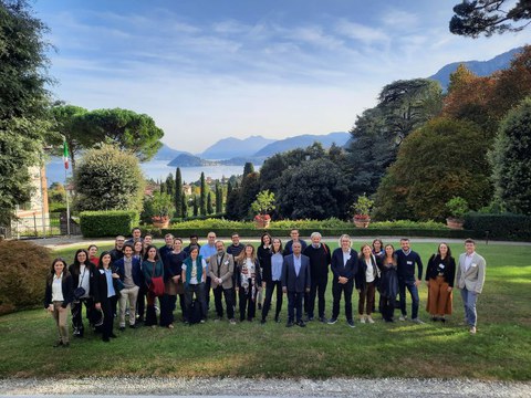 Group picture in a Mediterranean garden with a lake in the background.