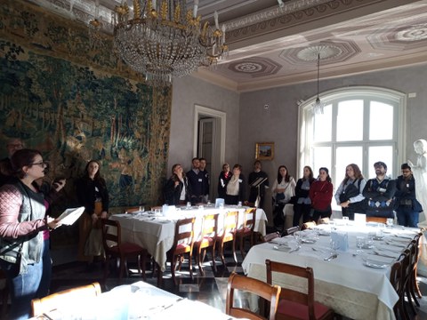 Group auf people standing in a dining room.