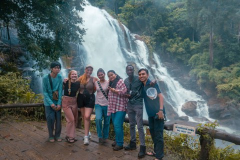 Group picture of international students in front of a waterfall.