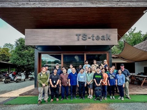 Group photo in front of a wooden building with the lettering “TS-teak”.