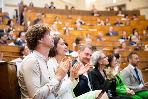 Students applauding in the lecture hall.