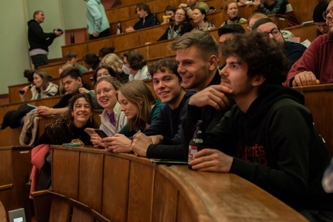 Laughing students on lecture hall benches.