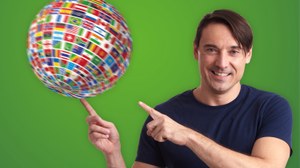 Image of a man pointing at a spinning globe made of many different countries' flags.