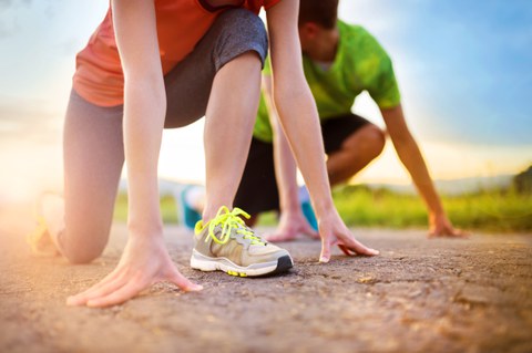 Das Foto zeigt zwei Jogger, die sich gerade für den Start fertig machen. Im Hintergrund scheint die Sonne.