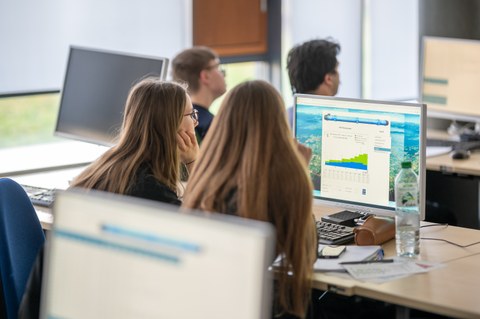 students working at the computer with CERN data
