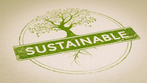 Foto von einem doppelt umrahmten Kreis in dem ein Baum rankt mit der Aufschrift Sustainable.