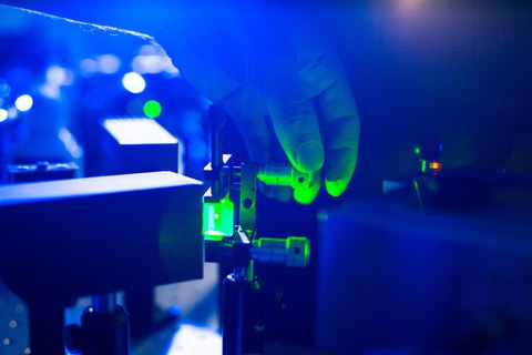 Bild eines elektromagnetischen Gerätes im blauen Licht. Ein Drehknopf wird grün angestrahlt und von einer Hand betätigt.